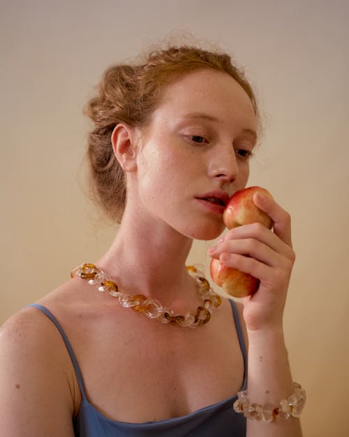 Woman in Blue Tank Top Holding Apples