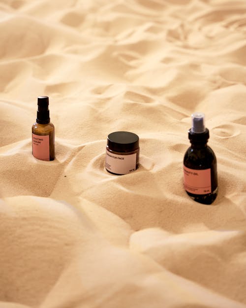 Close-Up Shot of Beauty Products on Brown Sand