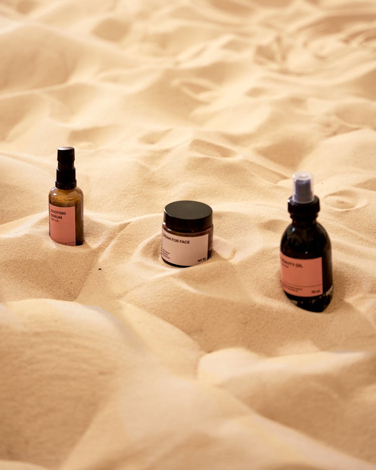 Close-Up Shot Of Beauty Products On Brown Sand