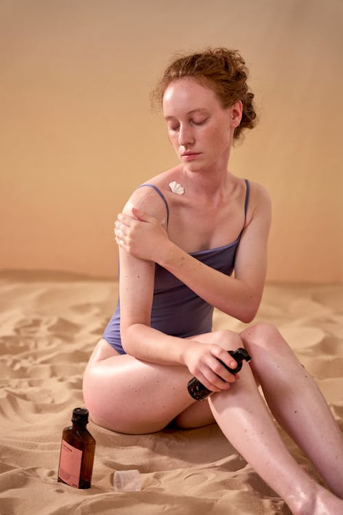 Free A Woman Applying Sunscreen on her Skin Stock Photo