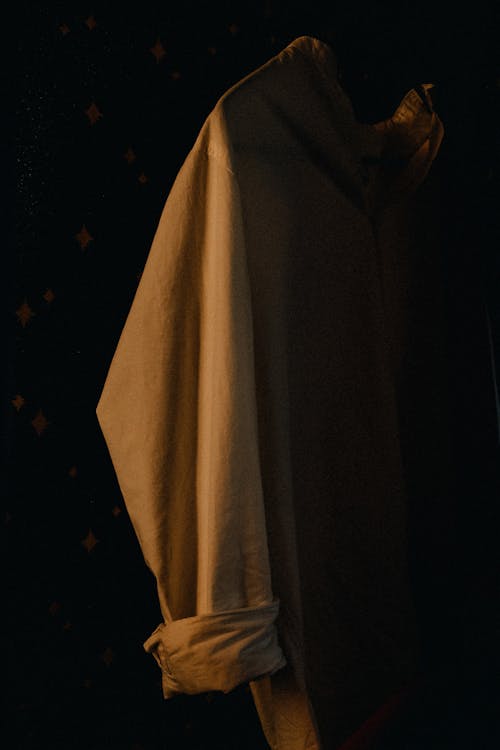 Darmowe zdjęcie z galerii z czarne tło, pionowy strzał, płaszcz