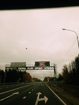 Moody highway scene with road signs and overcast skies, conveying solitude.