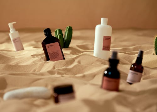 Free Cosmetic Products on a Beach Sand Stock Photo