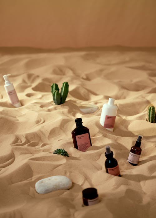 Free Cosmetic Products on a Beach Sand Stock Photo