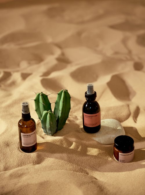 Free Cosmetic Products on a Beach Sand Stock Photo