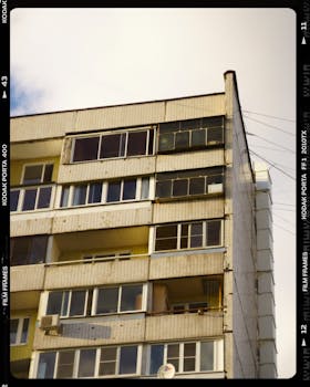 Low angle view of a modern urban apartment building facade with multiple balconies and glass windows.