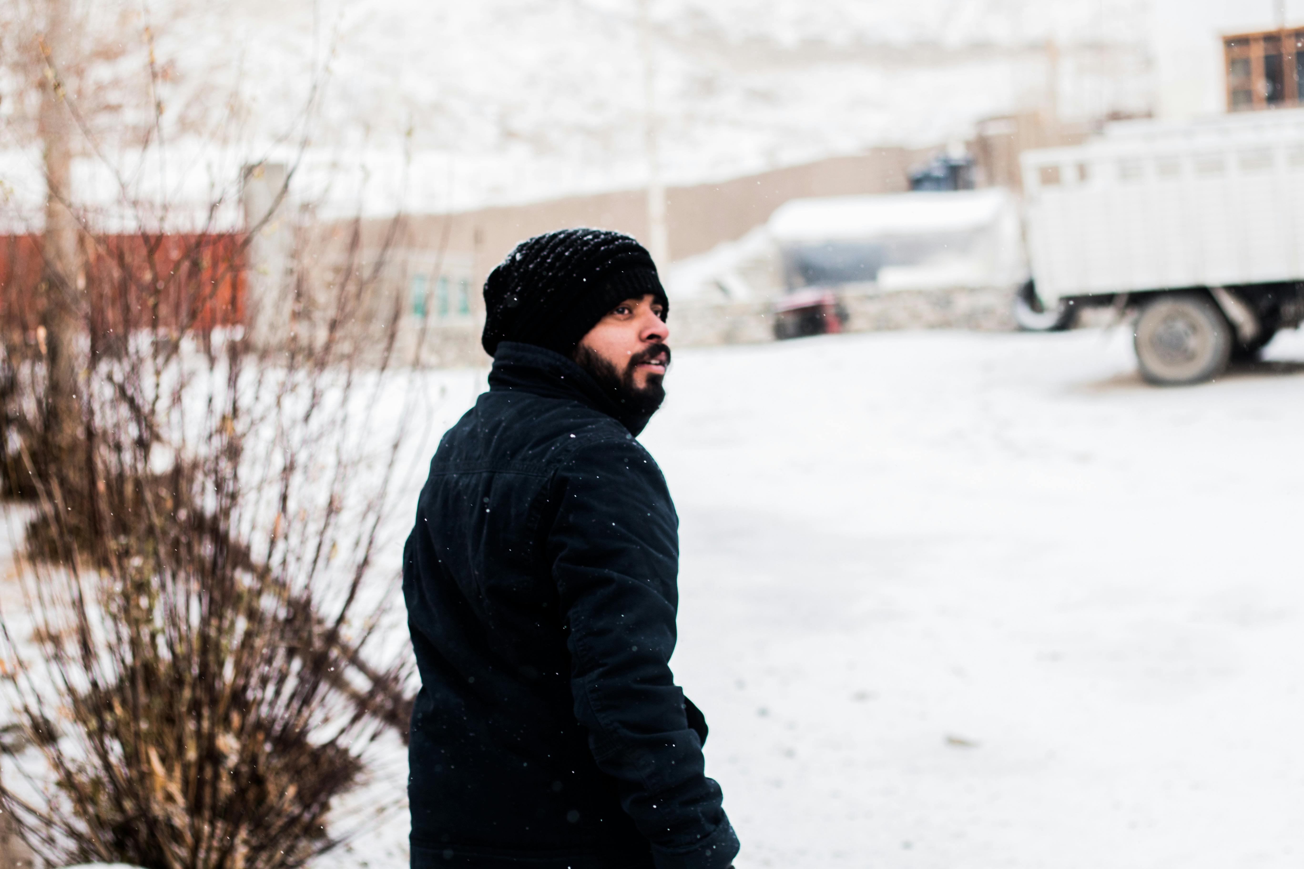 Hombre Con Ropa Abrigada Helándose En La Nieve Imagen de archivo