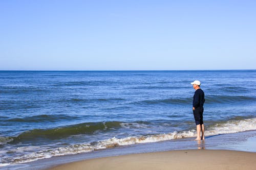 Man in Black Long Sleeve Shirt Standing on Beach
