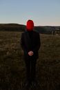 Man standing on the hill and having his head tied with a red crewel