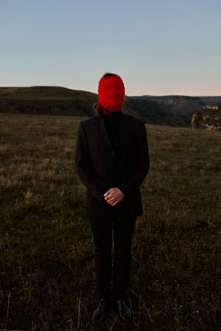 Man Standing On The Hill And Having His Head Tied With A Red Crewel