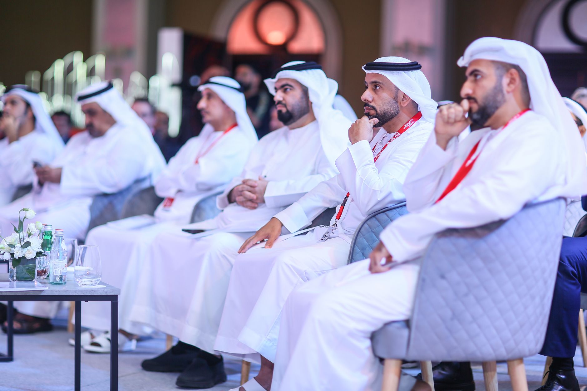 A business meeting in Dubai with men wearing traditional Middle Eastern clothing, focused and engaged.
