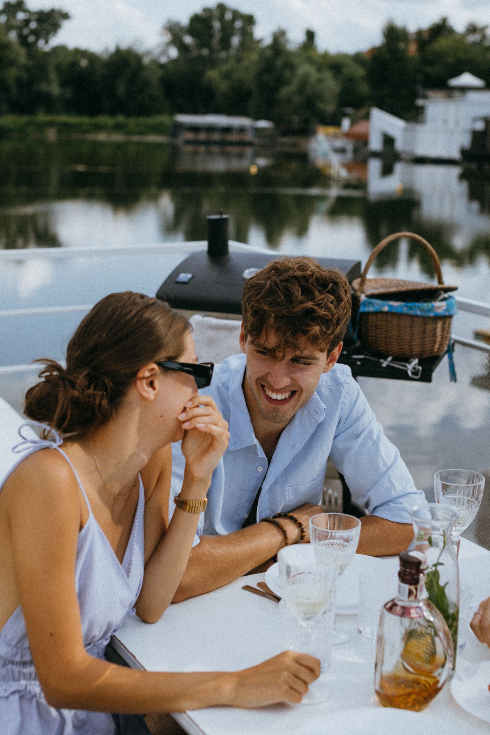 Couple laughing together outdoors during a riverside lunch date