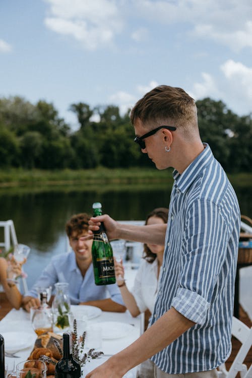 A Man in Sunglasses Holding a Champagne Bottle