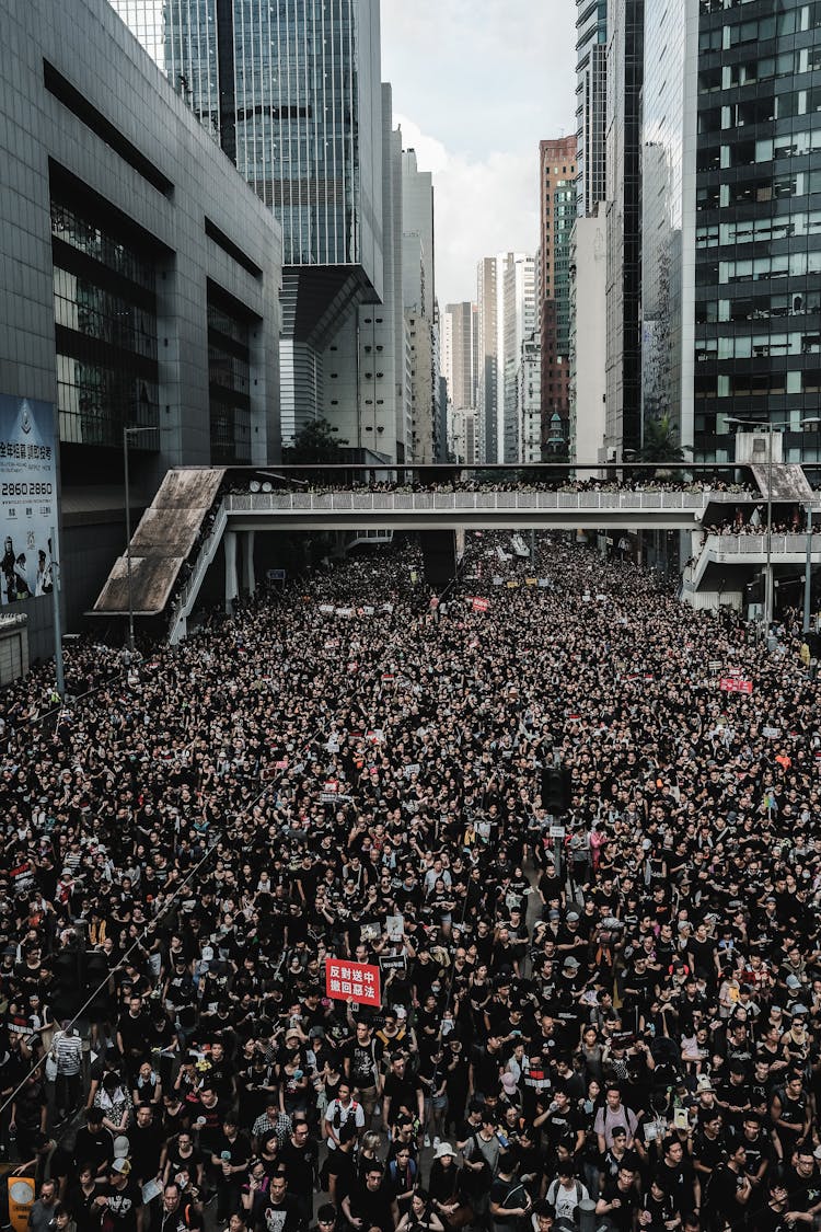 Crowd Of People Protesting And Walking On Street