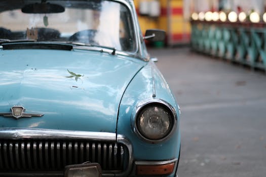 Close-up of a classic blue vintage car parked on a city street, exuding retro charm.
