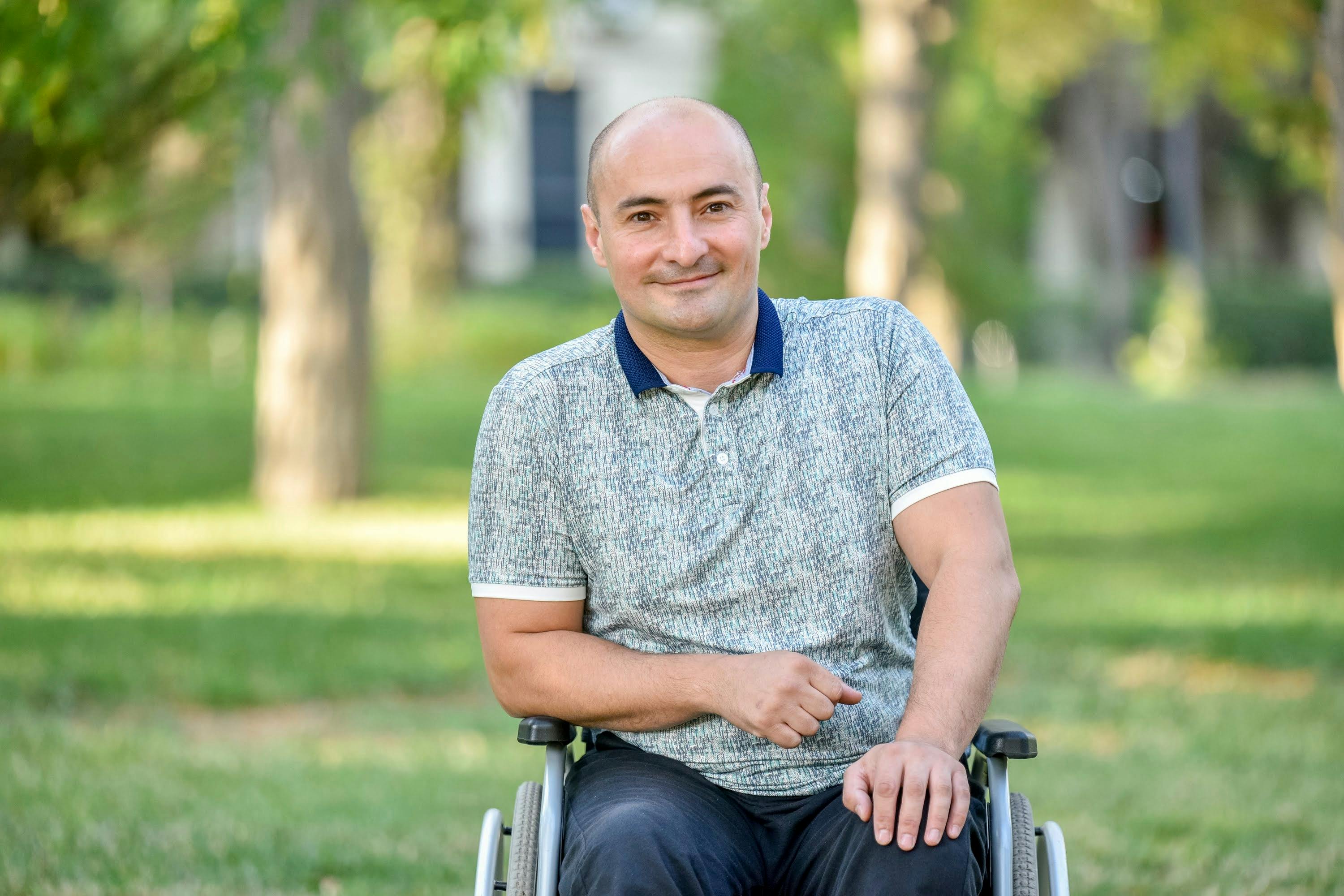 Cheerful man in wheelchair enjoying a sunny day outdoors.