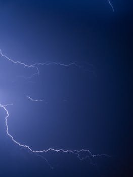 Captivating image of a lightning bolt illuminating a dark blue night sky. Perfect for stormy weather themes.