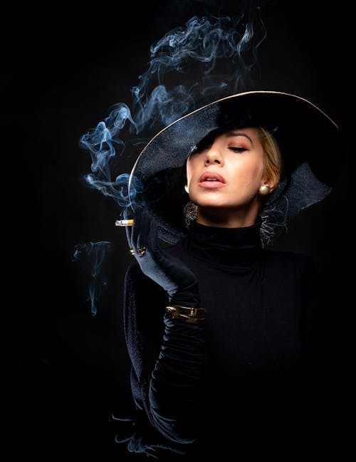 A Woman Wearing Black Hat While Smoking 