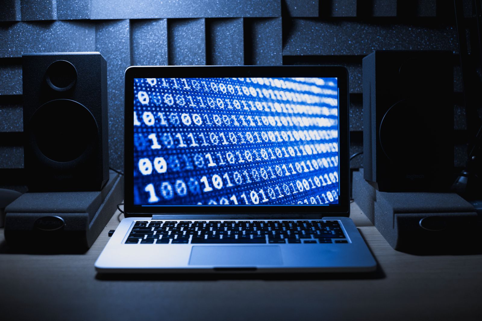 Laptop screen displaying binary code in a dark room, representing the cryptographic provenance manifest