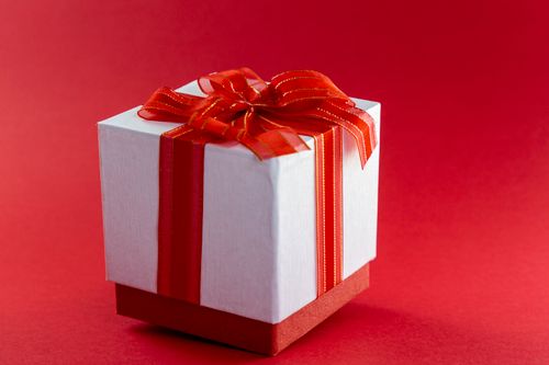 Free A stylish white gift box adorned with a vibrant red ribbon, perfect for any celebration. Stock Photo