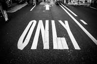 这张黑白照片展示了道路上的交通标记、人群和箭头