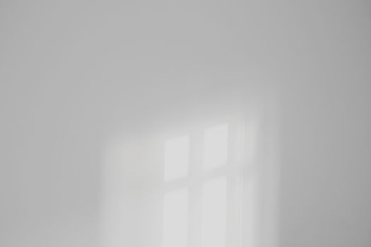 Soft light reflection on a plain white wall creating a minimalist aesthetic.