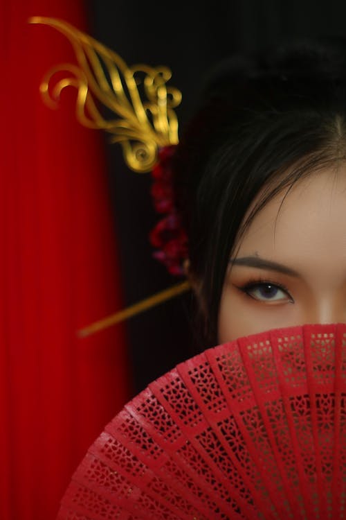 Woman Covering Her Face With Red Hand Fan