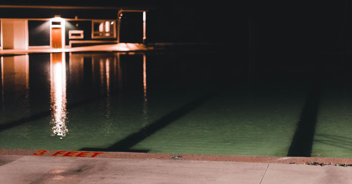 Piscina com iluminação LED Piscina iluminada à noite com superfície da água calma e refletiva