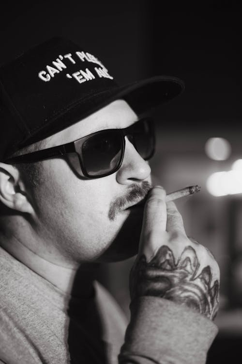 A Man Wearing Sunglasses Smoking Cigarette