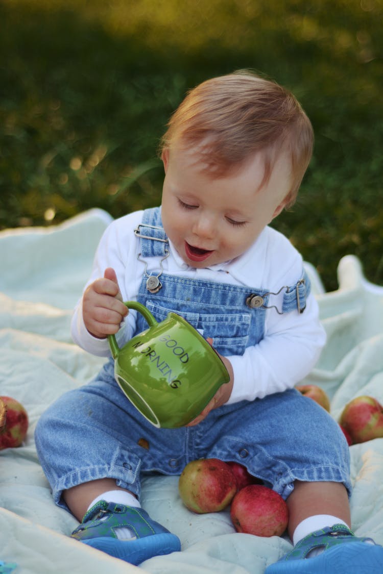 Toddler Holding A Green Mug