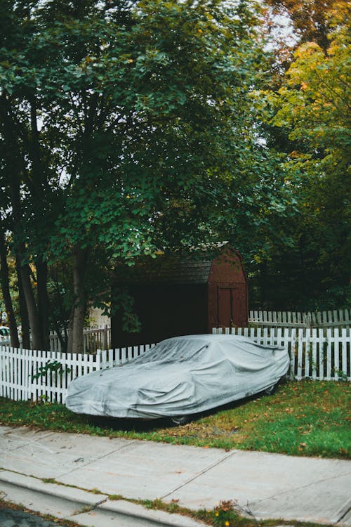 A Parked Car on a Lawn with Car Cover