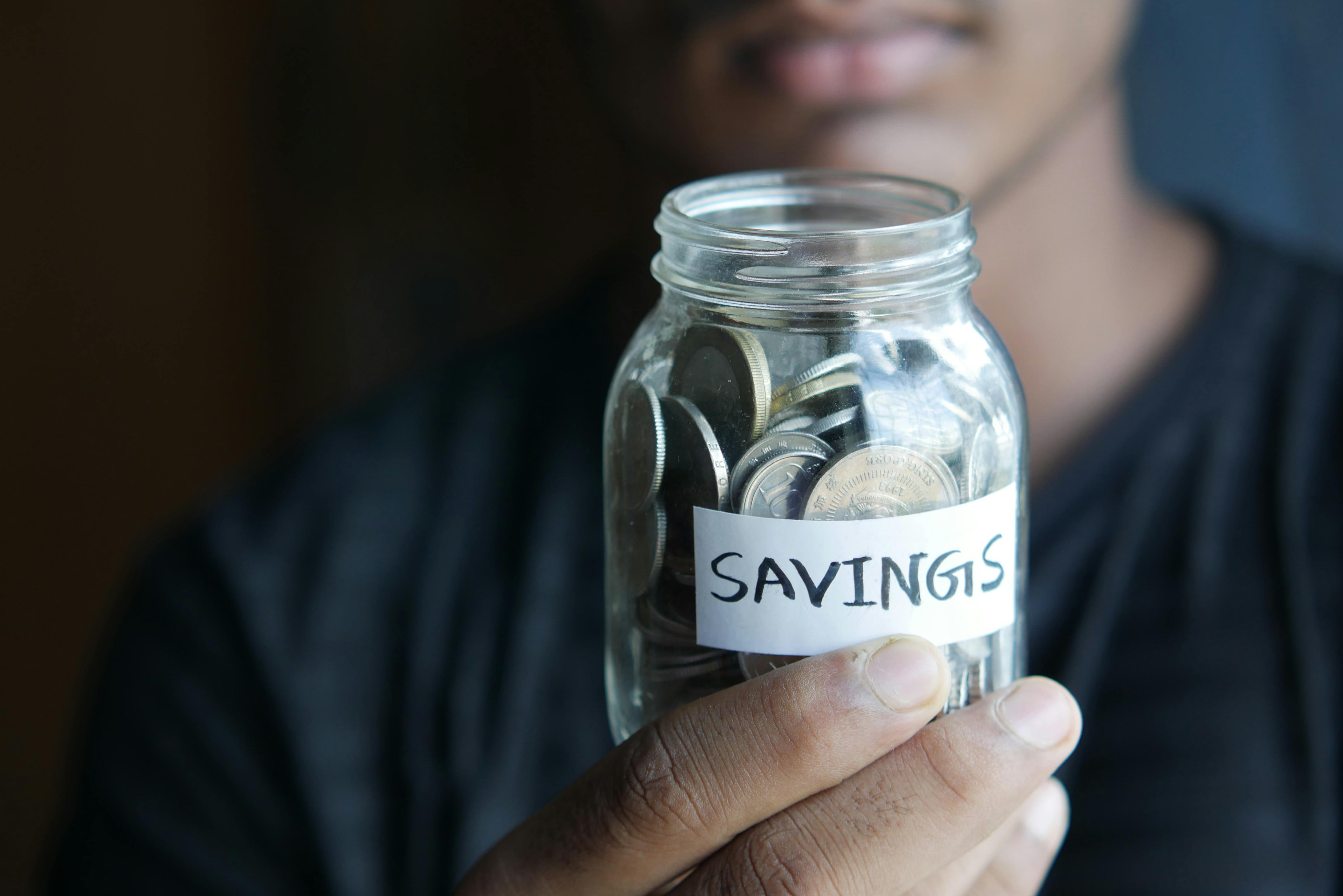 Close-Up Shot of a Person Holding a Jar with Coins · Free Stock Photo