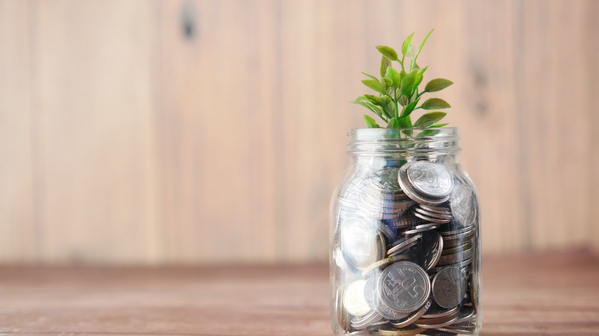 Jar filled with coins and a small plant, symbolizing automatic saving