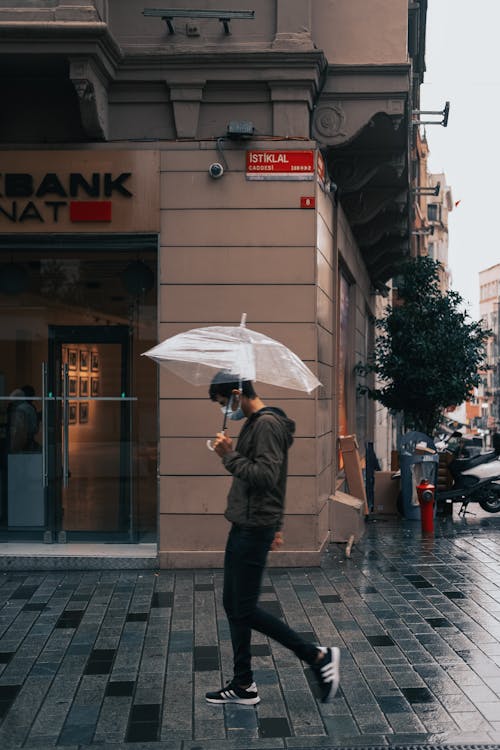 Man in Jacket Walking on the Sidewalk