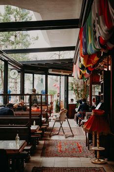 A modern restaurant interior featuring a glass-ceiling with eclectic decor and seating.