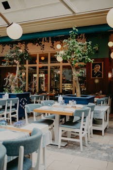 Charming restaurant interior featuring modern decor, wooden tables, and lush indoor plants.