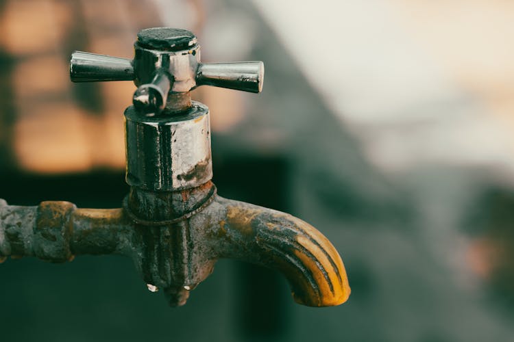 A Rusty Metal Faucet In Close-up Photography