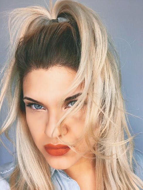 Close-up portrait of a blonde woman with striking makeup and hairstyle.