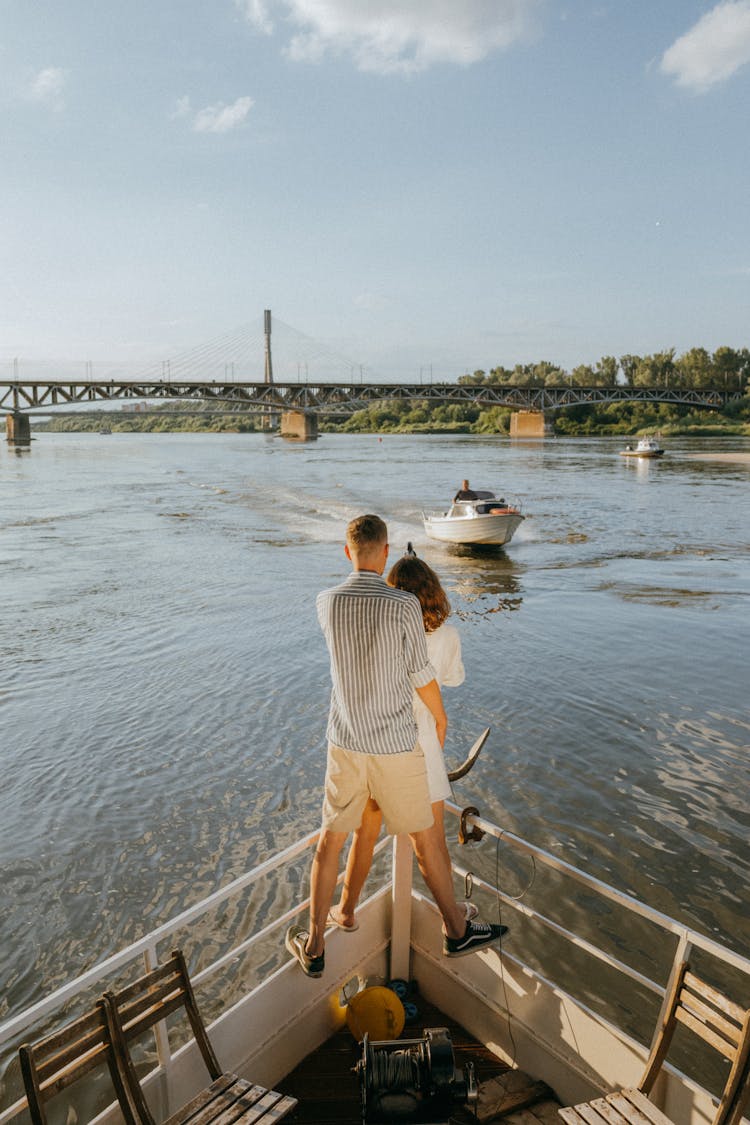 A Couple Standing Together At The Edge Of A Boat