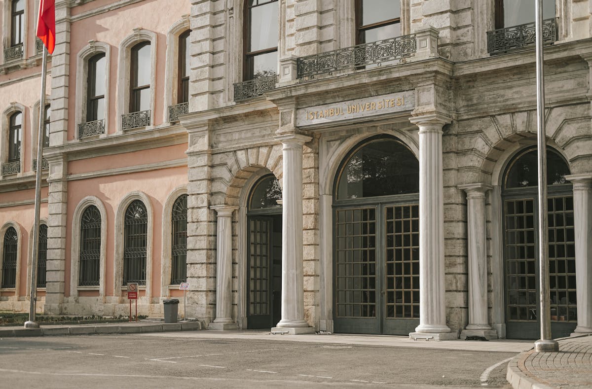 Young man in period-style coat standing against a moody sky, evoking a brooding romantic hero