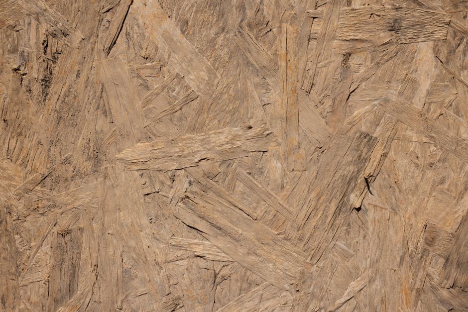 Close-up of a rough textured oriented strand board (OSB) wooden surface.