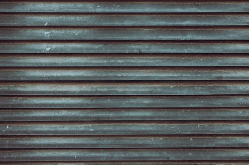 Free Close-up view of a rustic metal roll-up door with weathered textures. Stock Photo