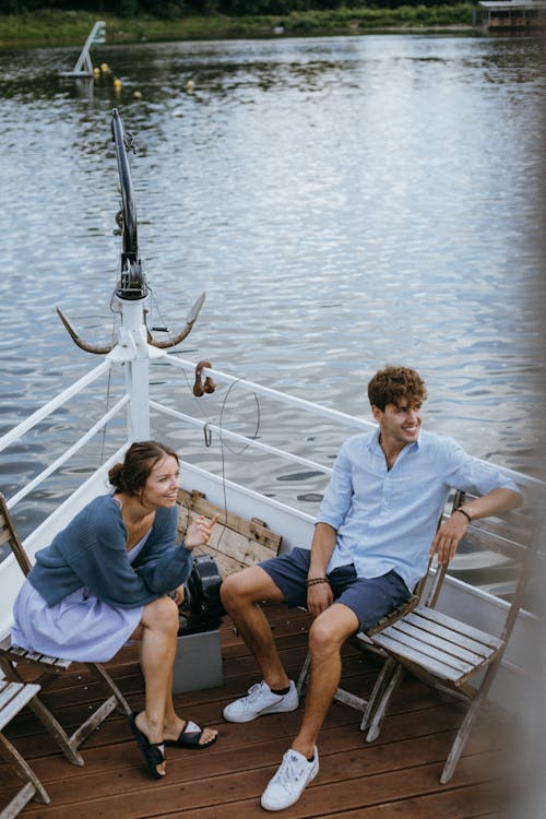 Free Man and Woman Sitting on Chair at the Boat Deck Stock Photo