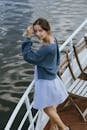 Woman in Blue Long Sleeve Shirt and White Skirt Standing on Wooden Dock
