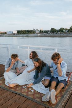 A group of young adults enjoying quality time together on a yacht with a view of the cityscape in the background.