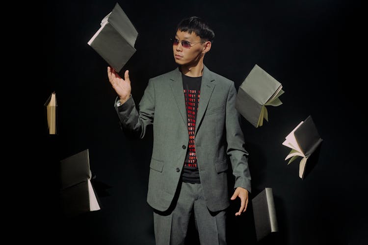 Man In Gray Suit Surround With Floating Black Books