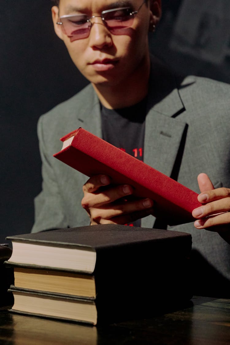 Man Wearing Eyeglasses And Holding Red Book