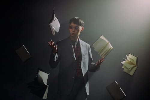 Man in a Dark Room Throwing Books 