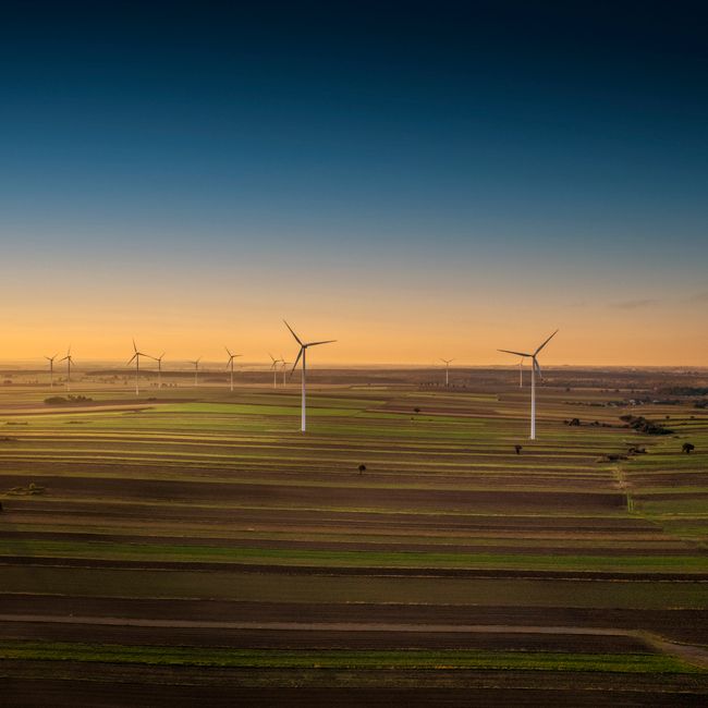 Aerial view of wind turbines in Iłża, Poland at sunset, showcasing sustainable energy in the countryside.