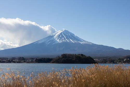 Snow Covered Volcano Near Body of Water